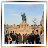 Monumento equestre a Santo Stefano al centro del piazzale del Bastione dei Pescatori a Budapest, circondato da torri gotiche in pietra bianca e turisti in una giornata soleggiata.