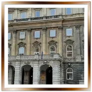 Facciata monumentale in pietra della Biblioteca Nazionale Széchényi vista dal Cortile dei Leoni nel complesso del Castello di Buda a Budapest, con il porticato d'ingresso a tre arcate.