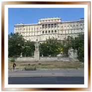 Prospettiva stradale di Piazza Dozsa a Budapest con il monumento scultoreo a György Dózsa, sormontato dall'imponente facciata della Biblioteca Nazionale Széchényi sulla collina del Castello di Buda.