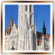 Il monumentale campanile gotico della Chiesa di Mattia a Budapest, con il caratteristico tetto di tegole colorate in ceramica Zsolnay e turisti sulla piazza della collina di Buda.