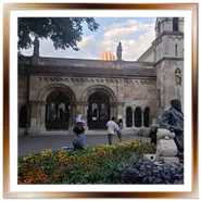 Chiostro della Cappella di Jak a Budapest con mongolfiera sullo sfondo e aiuole fiorite nel cortile di Vajdahunyad