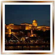 Il Palazzo Reale del Castello di Buda illuminato di notte, riflesso sul fiume Danubio a Budapest, visto dal lungofiume di Pest.