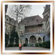 Cortile interno del Castello di Vajdahunyad a Budapest con facciate gotiche e la statua di Anonimo