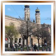Veduta panoramica esterna della Grande Sinagoga di Budapest con le torri moresche e la piazza circostante.
