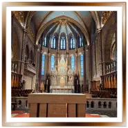 Vista dell'interno della Chiesa di Mattia a Budapest, con focus sull'altare maggiore dorato, le vetrate colorate dell'abside, le volte a crociera decorate con affreschi neo-gotici e i banchi in legno del coro.