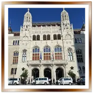 Facciata neogotica del nuovo edificio del Ministero dell'Interno a Buda, ricostruito con il Programma Hauszmann, con le guglie bianche, le bandiere e i furgoni della polizia davanti all'ingresso.