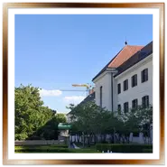 Vista dei giardini curati del Monastero Karmelita a Budapest, con la bandiera ungherese che sventola su un alto pennone a sinistra e l'edificio governativo sulla destra.