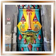 Antico portone in legno dipinto con un volto geometrico colorato al civico 12 di Kazinczy utca a Budapest