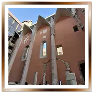 Antiche rovine gotiche del chiostro domenicano integrate nella facciata a specchi moderna dell'Hotel Hilton a Budapest, con colonne e archi a punta in pietra bianca.