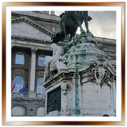 Monumento equestre in bronzo a Eugenio di Savoia davanti alla facciata e alla grande cupola verde del Palazzo Reale a Budapest, con alcuni visitatori sulla piazza.