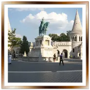 La statua equestre in bronzo verde di Re Santo Stefano su un imponente piedistallo in pietra bianca, situata nella piazza del Bastione dei Pescatori a Budapest tra due torri coniche neogotiche.