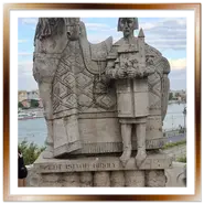 Inquadratura verticale della statua in pietra di Re Santo Stefano con il suo cavallo davanti alla Chiesa nella Roccia sulla collina Gellért a Budapest, con il Danubio sullo sfondo.