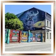 Muro con graffiti colorati di Paraman Art e grande murales del toro ungherese Szürkemarha in Kiraly utca a Budapest