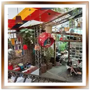 Interno del ruin pub Szimpla Kert a Budapest visto dalle scale con tendoni colorati e tavoli allestiti