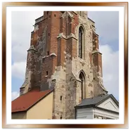 Inquadratura verticale della gotica Torre di Maria Maddalena nel quartiere del Castello di Buda a Budapest, con la facciata in mattoni rossi e pietra, vista dalla strada pavimentata.